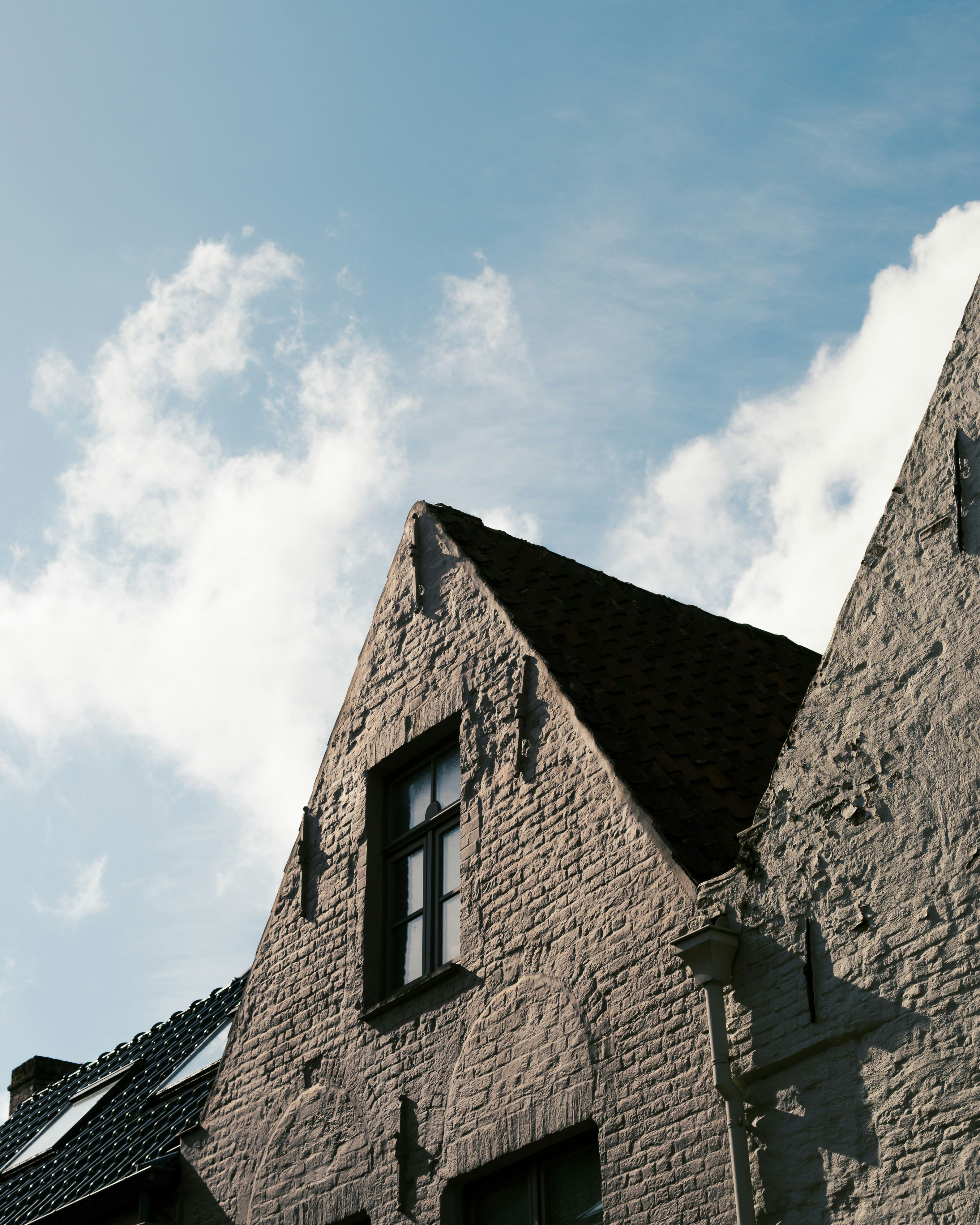 Cropped photo of the exterior of the top floor of an old stone building.